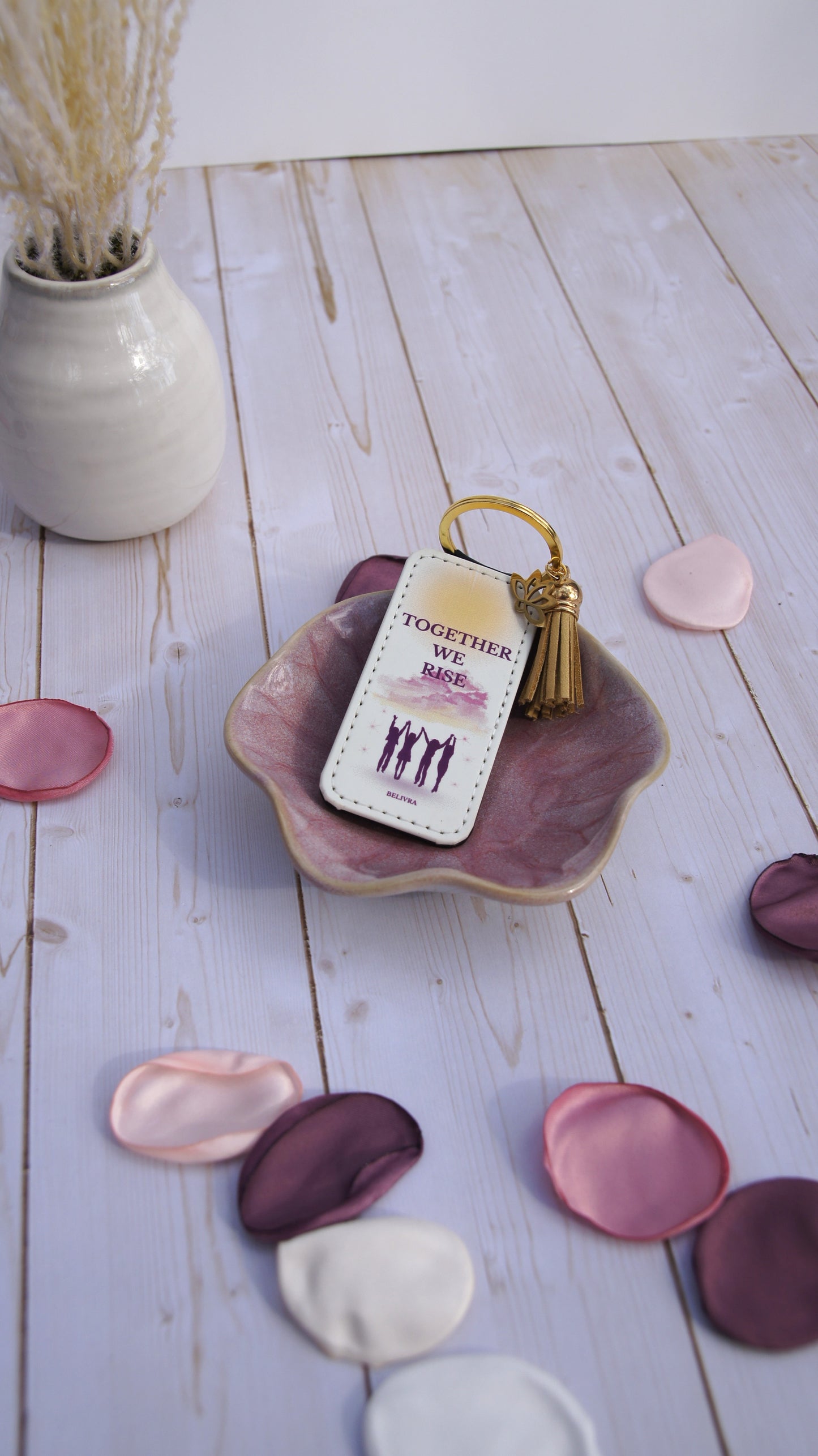 PU leather keychain with “Together We Rise” quote, gold lotus charm, and tassel, symbolizing sisterhood and empowerment by Belivra.