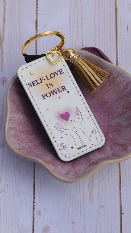 PU leather keychain with “Self-Love Is Power” quote, gold hollow heart charm, and tassel, symbolizing empowerment and confidence by Belivra.