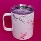 Angled view of Belivra ceramic mug with soft cherry blossom designs on both sides, featuring a spill-resistant lid. The mug showcases the delicate beauty of floral illustrations, perfect for sipping your favorite beverages while embracing mindfulness and creativity. Ideal for daily use, morning rituals, or as an empowering gift for women who appreciate elegance and self-care.