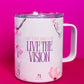 Angled view of Belivra ceramic mug with the inspirational phrase "Sip the Dream, Live the Vision" in bold purple text. The design is complemented by soft cherry blossom flowers on a pastel pink background, and the mug comes with a spill-resistant lid, ideal for enjoying your morning coffee or tea while embracing positive affirmations and motivation.