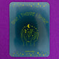 Belivra rectangular motivational magnet with the affirmation "Rise | Thrive | Shine" in bold yellow font – features celestial and floral hand illustration on a deep blue background. Displayed on a sparkly purple surface, perfect for empowering women’s workspaces, vision boards, and daily mindset reminders.