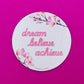 Belivra round motivational magnet with pink floral design and quote "dream believe achieve" in script font – displayed on a vibrant pink background. Inspirational and feminine fridge or office decor, perfect for women entrepreneurs, goal-setters, and self-growth lovers.