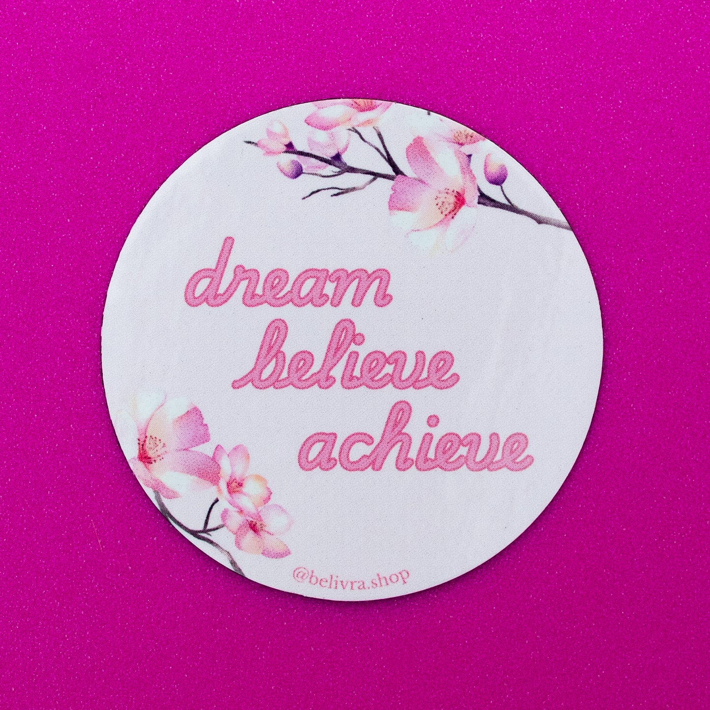 Belivra round motivational magnet with pink floral design and quote "dream believe achieve" in script font – displayed on a vibrant pink background. Inspirational and feminine fridge or office decor, perfect for women entrepreneurs, goal-setters, and self-growth lovers.