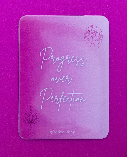 Belivra rectangular inspirational magnet with the quote "Progress over Perfection" in soft script font on a pink ombré background – features minimalist lotus and hand illustrations. Displayed on a vibrant pink surface, ideal for fridge decor, workspaces, and mindset motivation for women and creatives.