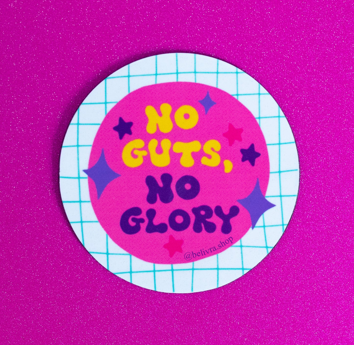 Belivra round motivational magnet with bold quote "No Guts, No Glory" in vibrant yellow and purple text on a hot pink background – accented with playful stars and a teal grid pattern. Displayed on a glittery pink surface, this fun and empowering magnet is perfect for bold dreamers, go-getters, and colorful desk or fridge decor.