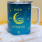 Front view of Belivra ceramic mug with a motivational quote "Pour. Sip. Conquer." in bold yellow text on a celestial blue background, featuring a crescent moon, lotus, and sparkling stars. Shown with a clear lid to keep beverages secure, perfect for mindful sipping and empowering morning routines. Ideal for tea, coffee, and gifting to women who embrace their journey with intention.