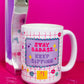 Belivra ceramic coffee mug with bold quote "Stay Badass. Keep Sipping." in playful pink and purple design – featuring a fun grid background with doodles like diamonds, gears, and stars. Displayed with a retro pink phone and scattered paperclips, this empowering mug is perfect for coffee-loving entrepreneurs, creatives, and bold women who start their day with confidence.