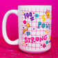 Left side of Belivra ceramic mug featuring colorful doodles and motivational words like "Power" and "Strong" on a red grid background – includes fun icons like a crown, flexing arm, dollar signs, and diamonds. Styled on a hot pink surface with scattered paperclips, this bold and empowering mug is perfect for women who love fun, energetic workspace vibes.
