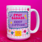 Front view of Belivra ceramic mug with empowering quote "Stay Badass. Keep Sipping." in bold red and purple text on a lavender background – set against a playful pink grid design with doodles like diamonds, flowers, and stars. Displayed on a hot pink surface with scattered paperclips, perfect for confident women, office desk vibes, and motivational coffee moments.