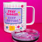 Belivra insulated tumbler mug with motivational quote "Stay Badass. Keep Sipping." in bold pink and purple text – shown with removable clear lid and a playful pink grid background featuring floral and diamond doodles. Perfect for hot or cold drinks, this stylish and empowering travel mug is ideal for busy women, entrepreneurs, and coffee lovers on the go.