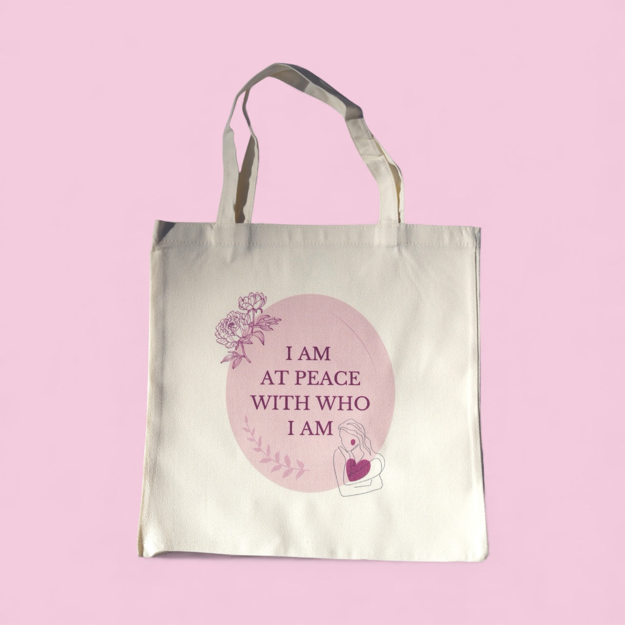 Cream tote bag with the quote “I Am at Peace with Who I Am” in soft plum and blush tones, featuring floral and feminine line art symbolizing mindfulness and self-love.