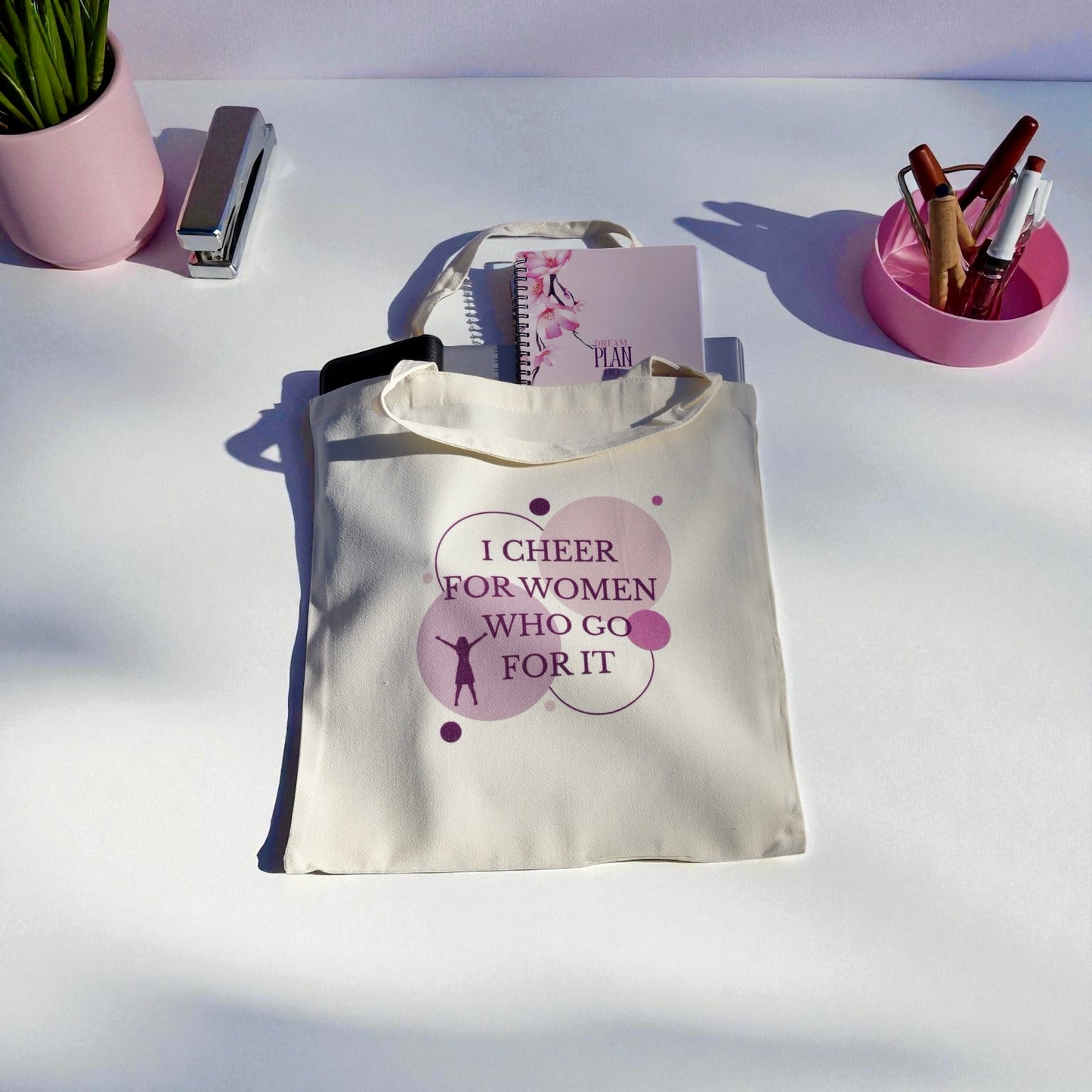 Cream polyester tote bag with “I Cheer for Women Who Go For It” quote in purple, symbolizing sisterhood and empowerment by Belivra.